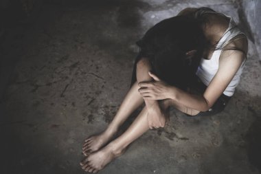 Boş bir odada yalnız oturan üzgün kadın. Aile içi şiddet, Uluslararası Kadınlar Günü.