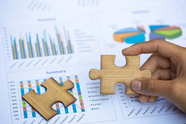 Jigsaw puzzle in the hand of a businessman,  Business team assembling Jigsaw puzzle.