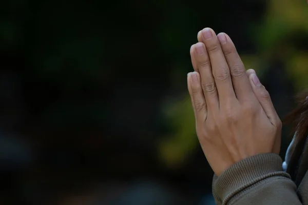 Praying hands with faith in religion and belief in God on dark background. Pay respect.  Namaste or Namaskar hands gesture.