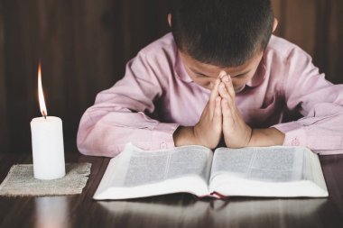 Çocuk Tanrı 'ya dua ediyor. İnanç, maneviyat ve din için dua kavramına sarılmış eller..