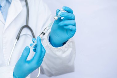 Laboratuvarda elinde sıvı aşılarla bir şırınga tutan doktor ya da bilim adamı. Covid-19 Corona virüsüne karşı kavramsal mücadele.