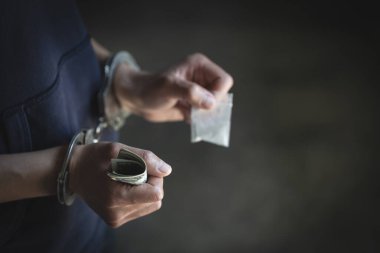 Tutuklanan uyuşturucu satıcısı kelepçelenmiş. Uyuşturucu karşıtı. Uyuşturucu kavramı.