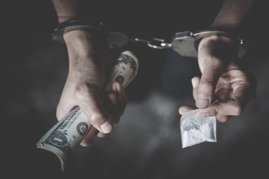 Uyuşturucu satıcısı kelepçe, uyuşturucu parası ve uyuşturucu tehdidi konseptiyle tutuklandı. Uyuşturucu ve Kaçakçılığına Karşı Uluslararası Gün