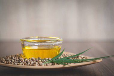 Tohumların ve yaprakların yakınındaki bir kasede bulunan kenevir yağı. Çıkarma bileşimi. Organik bitkisel tıbbi ürünler. Hastalık tedavisi. Alternatif tıp.