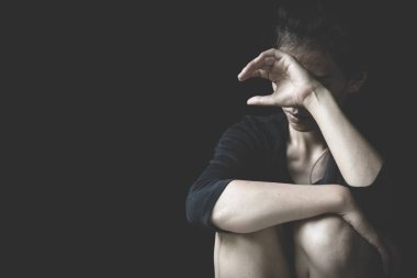 Yerde oturan bunalımlı kadın. Korkmuş, yalnız, depresyonda, suistimal edilmiş. Bunalımlı kadın. Cinsel taciz mi? Koyu tonlarda hüzünlü.