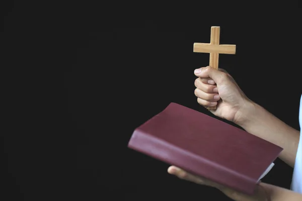 Woman praying while holding Bible and cross, Pray in the Morning , Woman praying with hands together on the Sunrise background.