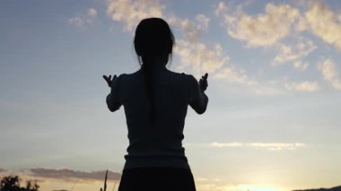 Bir kadın dua ederken avuçlarını kaldırır. İsa 'ya olan dini inanç ve inanç Kutsama, yardım, umut, inanç, sevgi ve sadakat.