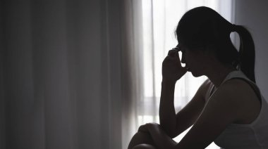 Depresyondaki genç kız karanlık odada kanepede tek başına oturuyor. Kadınlara karşı şiddeti ve tecavüzü durdurma kavramı. Kadınlara yönelik cinsel taciz ve şiddeti durdurun.