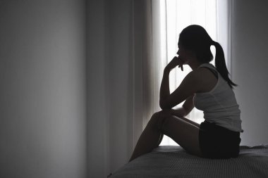 Depresyondaki genç kız karanlık odada kanepede tek başına oturuyor. Kadınlara karşı şiddeti ve tecavüzü durdurma kavramı. Kadınlara yönelik cinsel taciz ve şiddeti durdurun.