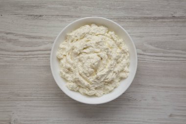 Lezzetli Ricotta peyniri, beyaz kasede, üst manzara. Yukarıdan, dümdüz uzanmış. 
