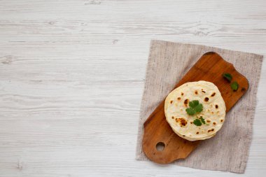 Ev yapımı Roti Chapati tahta üzerinde düz ekmek, üst manzara. Yukarıdan, dümdüz yatıyordu. Metin için boşluk.