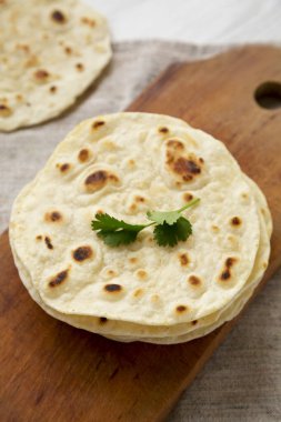 Ev yapımı Roti Chapati tahta üzerinde düz ekmek, alçak açılı. Yakın plan..