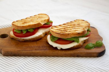 Tasty ızgara Caprese Panini (Mozzarella, Domates ve Basil), ahşap bir tahta üzerinde, yan görüş. Yakın plan..
