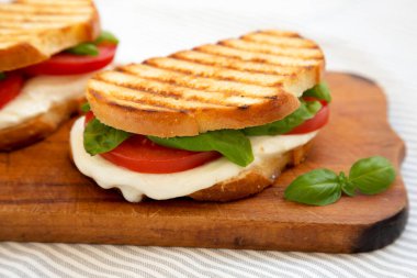Tasty ızgara Caprese Panini (Mozzarella, Domates ve Basil), ahşap bir tahta üzerinde, yan görüş. Yakın plan..