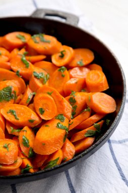 Ev yapımı sotelenmiş havuç, dökme demir tavada, yan görüş. Yakın plan..