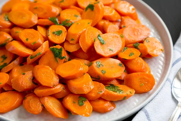 Siyah arka planda bir tabakta ev yapımı Sauteed Havuç, yan görüş. Yakın plan..