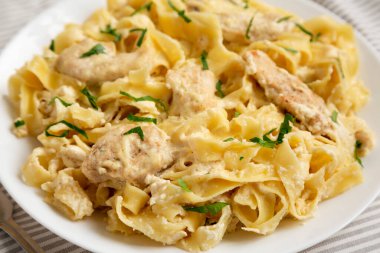 Beyaz bir tabakta ev yapımı Fettuccine Alfredo. Yakın plan..