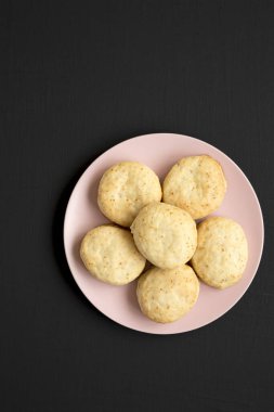 Siyah arka planda pembe bir tabakta ev yapımı Flaky Buttermilk Bisküvileri. Boşluğu kopyala.