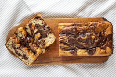 Beyaz ahşap zemin üzerinde ahşap bir tahta üzerinde ev yapımı Muzlu Çikolatalı Ekmek, üst manzara. Dümdüz, tepeden, yukarıdan. 