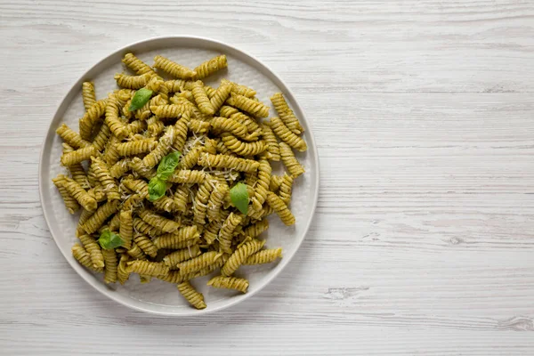 พาสต Pesto Twist แบบโฮมเมดบนจานบนพ วไม ขาวท อปว าใช ายจากด านบนวางแบน — ภาพถ่ายสต็อก