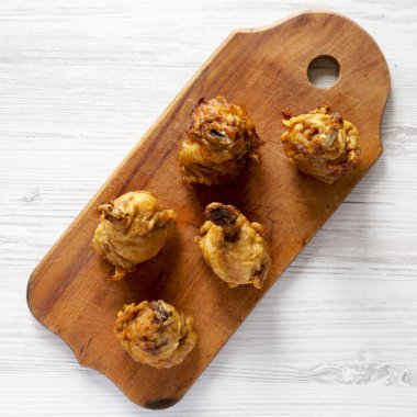 Beyaz ahşap bir yüzey üzerinde ahşap bir tahta üzerinde ev yapımı Baharatlı Tavuk Lolipopu. Yukarıdan, dümdüz yatıyordu. Yakın plan..