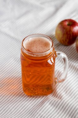 Cam kavanozdaki sert elma birası kumaş üzerinde, düşük açılı görünüm. 