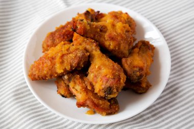 Ev yapımı baharatlı tavuk kanatları beyaz bir tabakta, yan görünüşte. Yakın plan..