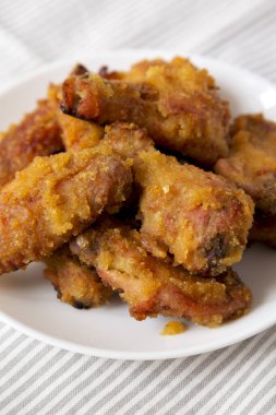 Ev yapımı baharatlı tavuk kanatları beyaz bir tabakta, yan görünüşte. Yakın plan..