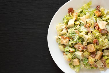 Ev yapımı domuz pastırması Avokado Sezar Salatası, peynirli ve kızarmış ekmek, en iyi manzara. Dümdüz, tepeden, yukarıdan. Boşluğu kopyala.