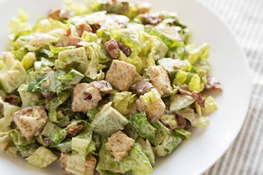 Peynirli ve kızarmış ekmekli ev yapımı jambonlu Sezar Salatası. Yakın plan..