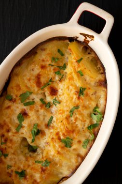 Siyah bir yüzeyde ev yapımı karbonhidratlı patates, üst manzara. Dümdüz, tepeden, yukarıdan. Yakın plan..