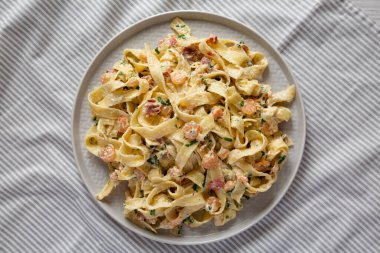 Ev yapımı sarımsaklı karides pastırmalı Alfredo, en iyi manzara. Dümdüz, tepeden, yukarıdan. 