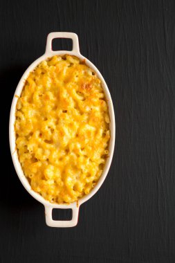 Siyah bir yüzeyde ev yapımı makarna ve peynirli makarna. Dümdüz, tepeden, yukarıdan. Boşluğu kopyala.
