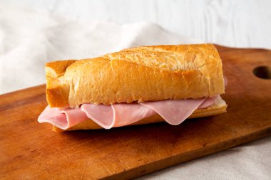 Ev yapımı Parisli Jambon-Beurre Sandviçi. Köy tahtasında, yan manzaralı. Yakın plan..