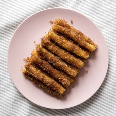 Ev yapımı Churro Isırıkları. Pembe bir tabakta, üstten görünüyor. Düz yatıyordu, üstten, yukarıdan.. 