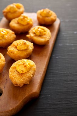 Kaba ahşap bir tahtanın üzerinde Paprika ile ev yapımı kızarmış Deviled Eggs, yan görüş. Boşluğu kopyala.