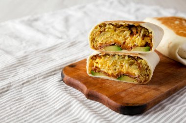 Ev yapımı yumurta burrito, Avocado ve pastırmalı, ahşap bir tahta üzerinde, yan görüş. Boşluğu kopyala.