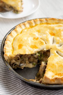 Beyaz bir tabakta beyaz ahşap bir yüzey üzerinde ev yapımı tavuklu börek..