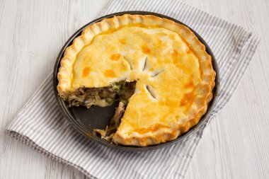 Beyaz bir tabakta beyaz ahşap arka planda ev yapımı tavuklu börek..