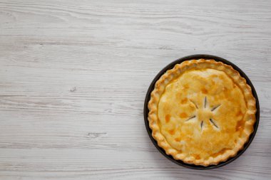 A Piece of Chicken Pot Pie on a white wooden background, top view. Flat lay, overhead, from above. Space for text.