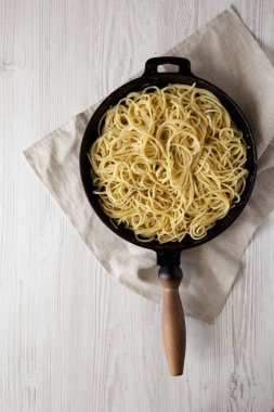 Ev yapımı Cacio E Pepe Pasta ve Pecorino Romano ve Pepper, tepeden bakıldığında dökme demir bir tavada. Düz yatıyordu, üstten, yukarıdan. Metin için boşluk.