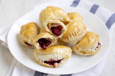 Beyaz ahşap arka planda, düşük açılı, ev yapımı vişneli turtalar..