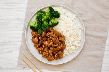 Beyaz ahşap arka planda, üzerinde pirinç ve brokoli olan ev yapımı Teriyaki tavuğu. Dümdüz, tepeden, yukarıdan. 