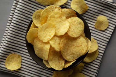 Ekşi krema ve soğan aromalı cipsler bir kâsede. Düz uzanın, başınızın üstünde.