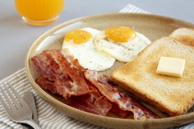 Tabakta ev yapımı Amerikan Pastırmalı Yumurta ve Tost Kahvaltısı. Yakın plan..