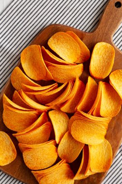 Tahtada kırmızı biber aromalı patates cipsi..