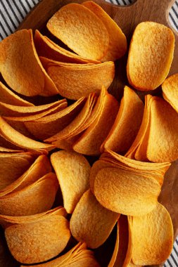 Tahta üzerinde kırmızı biber aromalı patates cipsi. Yakın plan..