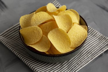 Ekşi krema ve soğan aromalı cipsler kasede, yan görüş..