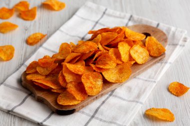 Tahta tahtada kırmızı biber aromalı patates cipsi, yan görüş..