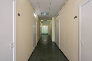 Ofis binasındaki dar koridorun modern iç mimarisi.